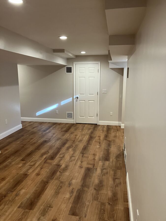 Finished basement — framing around ductwork and beams, recessed lighting, utility door