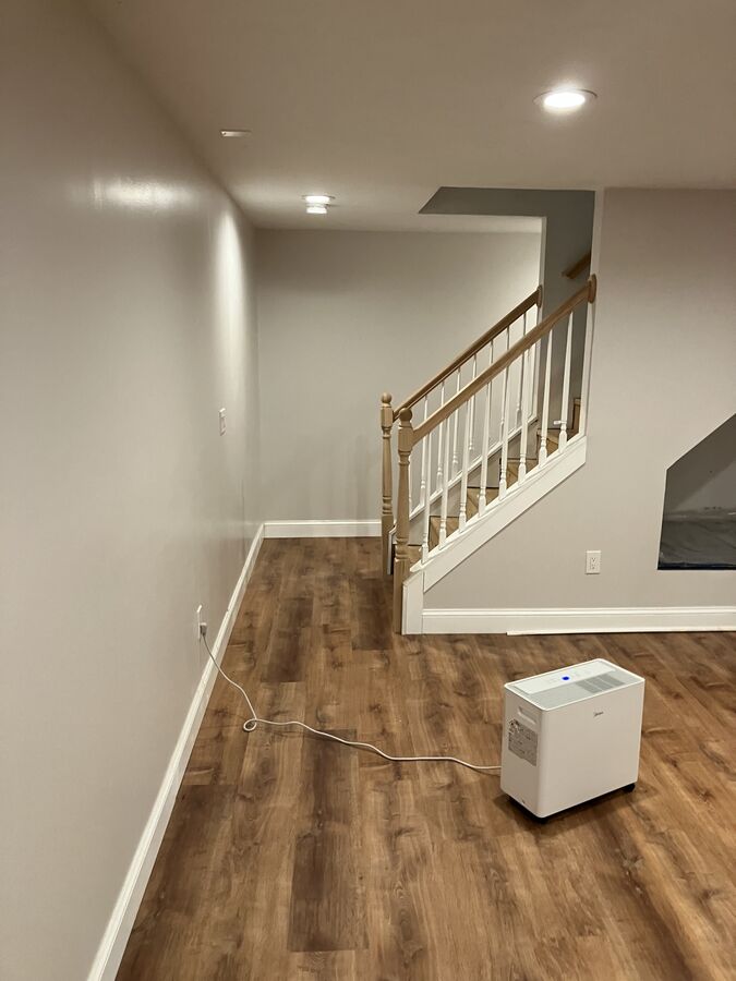 Finished basement — staircase with white banister and oak handrail, recessed lighting